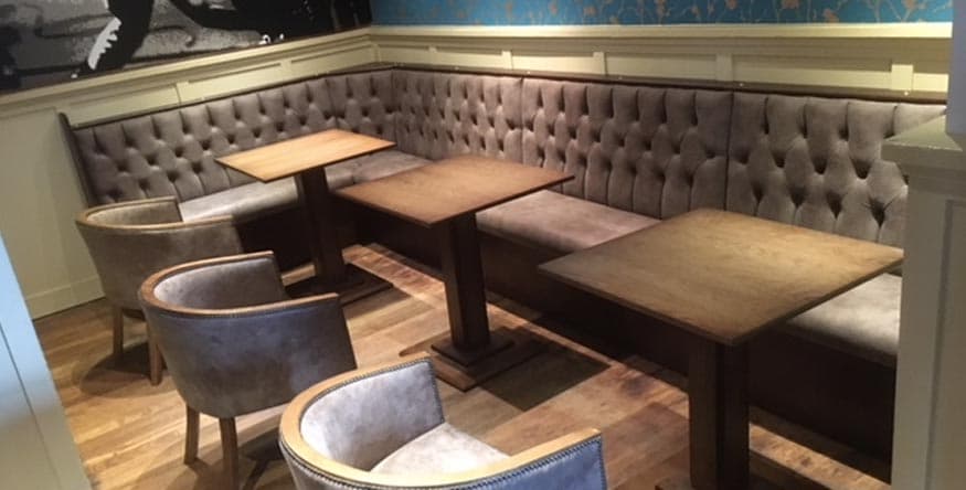 Fixed upholstered banquette seating in a pub being cleaned professionally